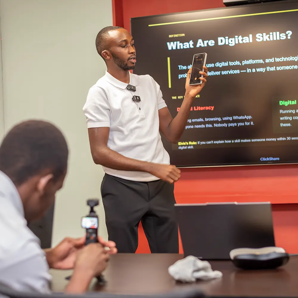 Elvis W. teaching digital skills with a presentation screen in Nairobi